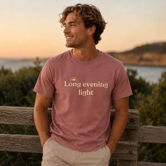 Male model wearing the Long Evening Light T-Shirt in mauve, styled outdoors in soft evening light for a relaxed seasonal outfit.