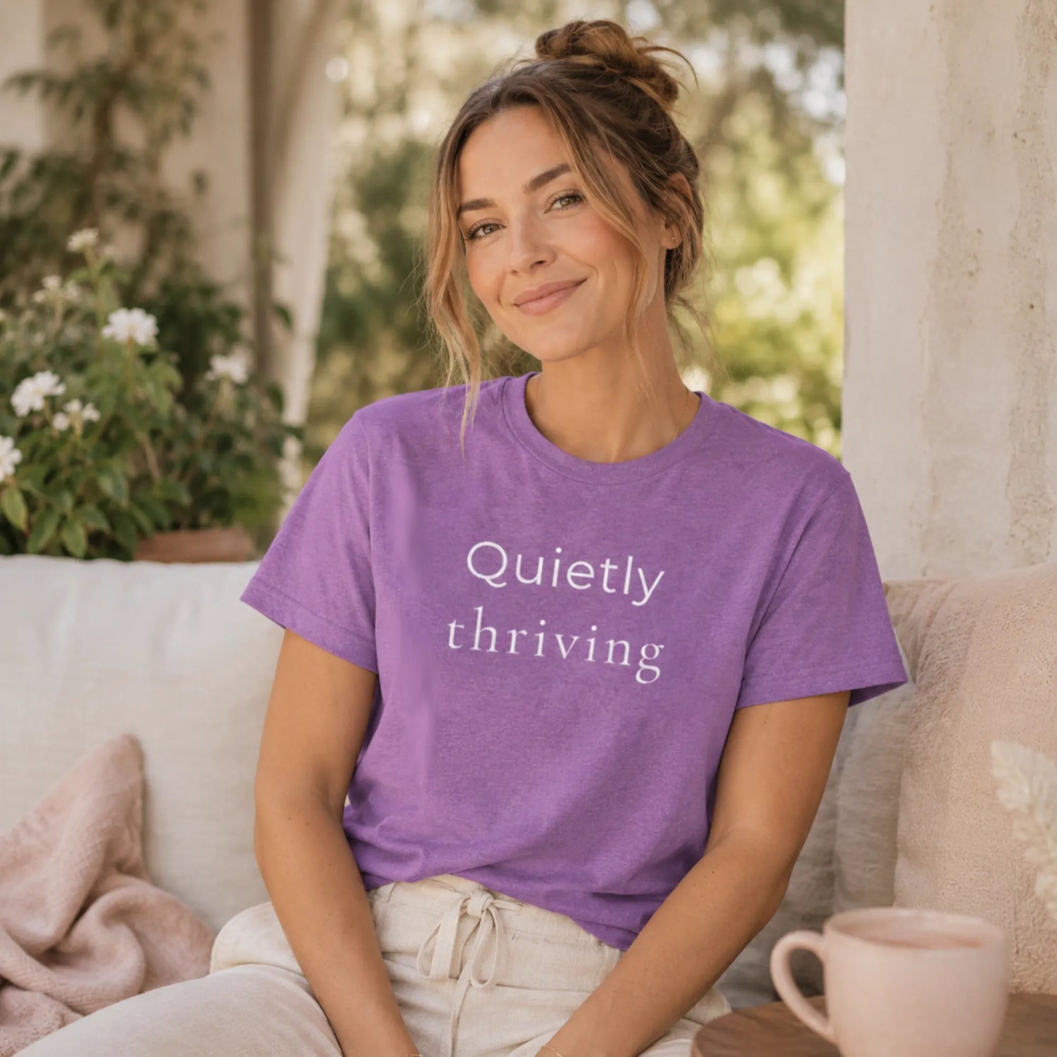 Woman wearing a heather purple Bella Canvas T-shirt with “Quietly thriving” text, relaxed lifestyle mockup