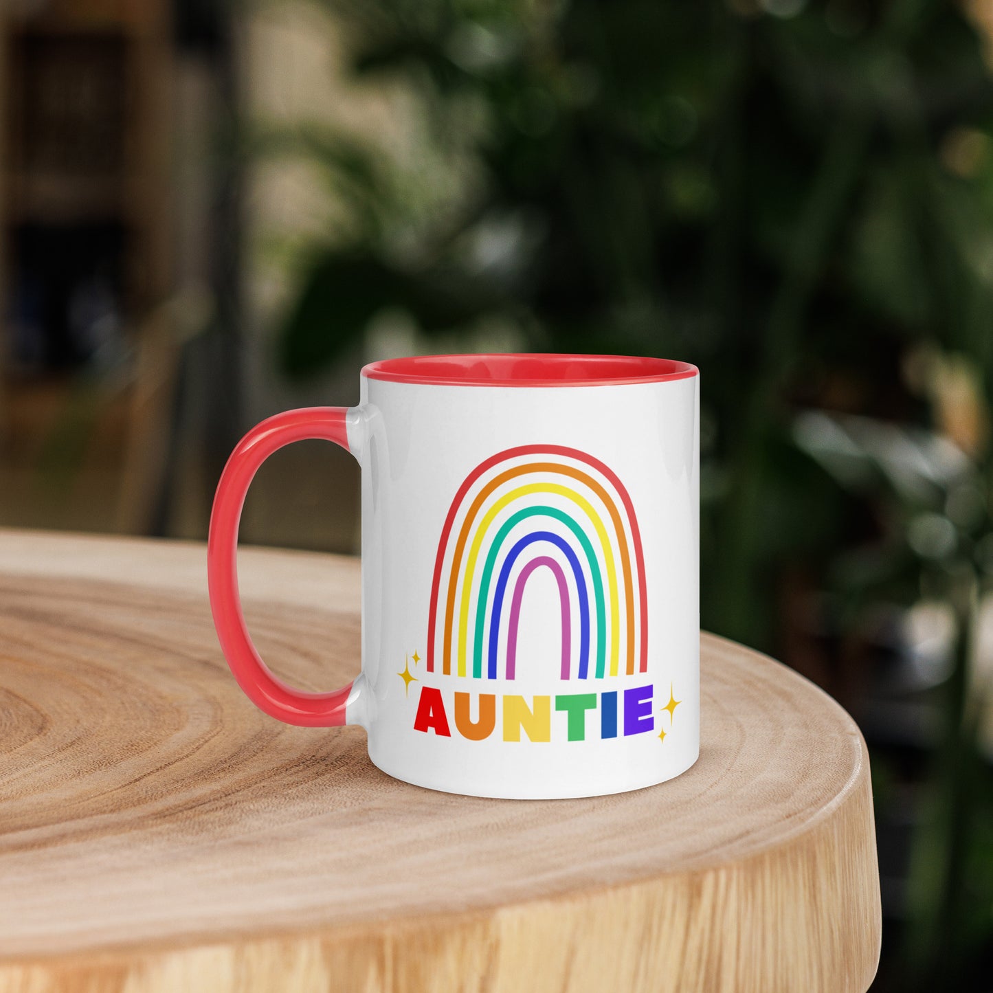 Auntie rainbow ceramic mug with red interior placed on wooden table in home setting