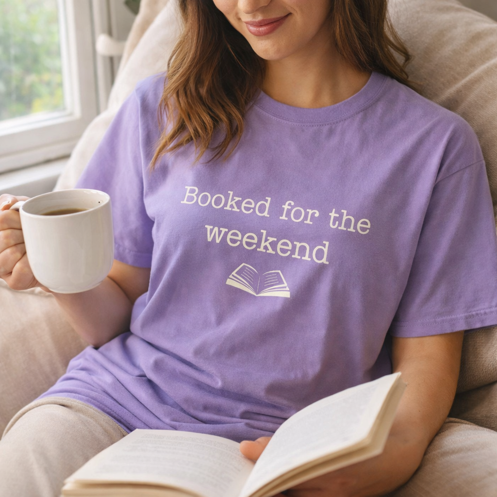 woman wearing violet booked for the weekend t-shirt reading by window cosy book lover