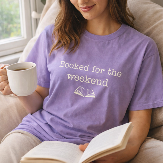 woman wearing violet booked for the weekend t-shirt reading by window cosy book lover