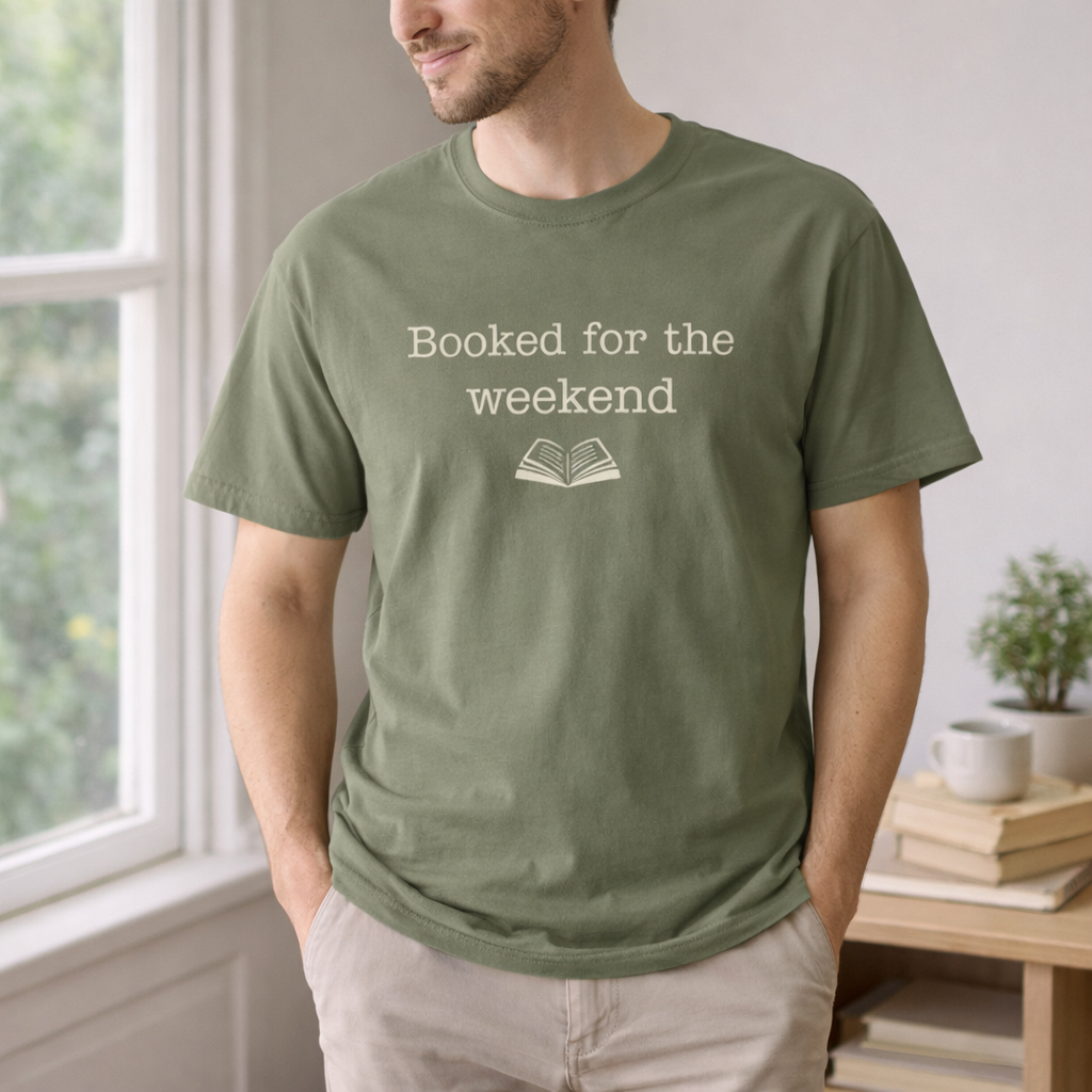 man wearing moss green booked for the weekend t-shirt standing by window casual book lover shirt