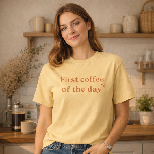Woman wearing butter First coffee of the day Comfort Colors T-shirt in cosy sunlit kitchen