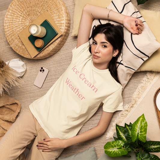 Woman relaxing on cushions wearing ivory Ice Cream Weather graphic T-shirt, warm summer slow living aesthetic