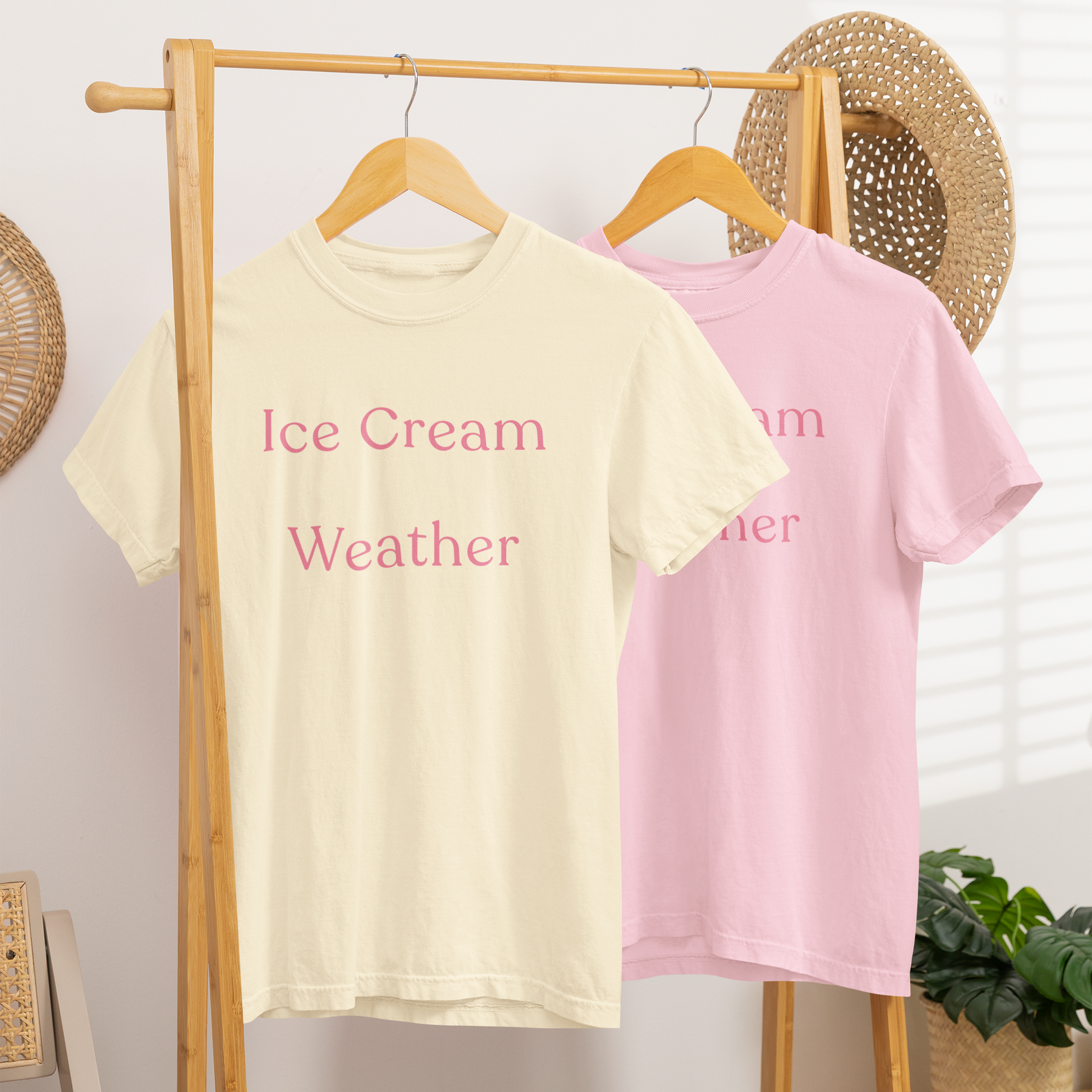 Ice Cream Weather T-shirts in ivory and blossom hanging on wooden rail, summer lifestyle graphic tee in two colour options