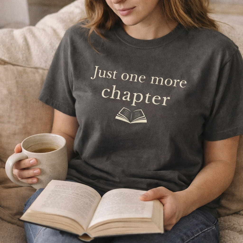 Woman reading a book with coffee wearing Just one more chapter book lover T-shirt in cosy lifestyle setting