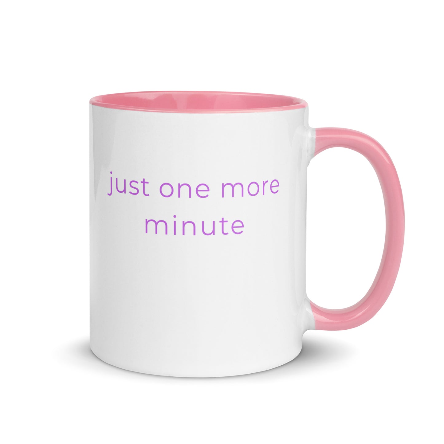 Minimalist ceramic coffee mug with pink handle and the phrase “just one more minute”, designed for calm slow mornings and cosy everyday moments.