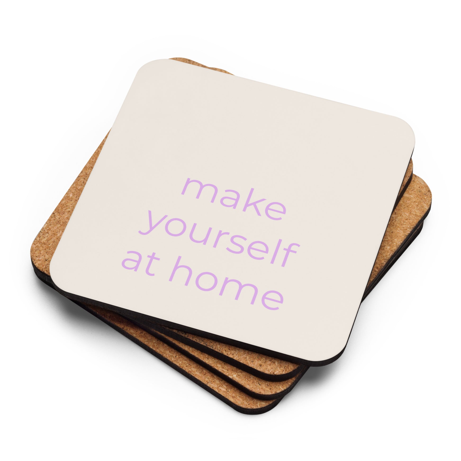 Stack of neutral cork-back coasters with “make yourself at home” text in soft purple showing layered edges