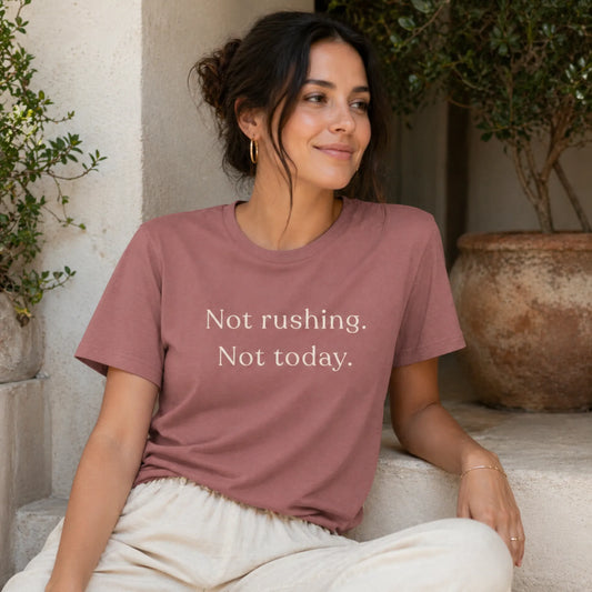 Female model wearing a heather mauve Not Rushing Not Today T-Shirt in a calm, relaxed lifestyle setting.