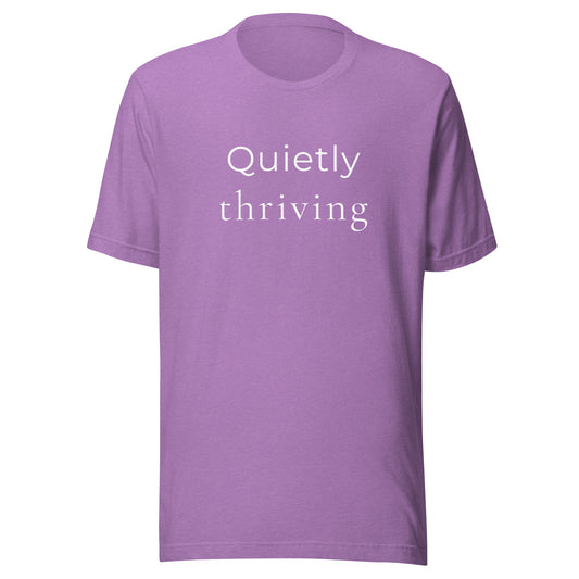 Minimal “Quietly Thriving” graphic T-shirt in heather purple with soft white text on Bella+Canvas 3001 unisex tee