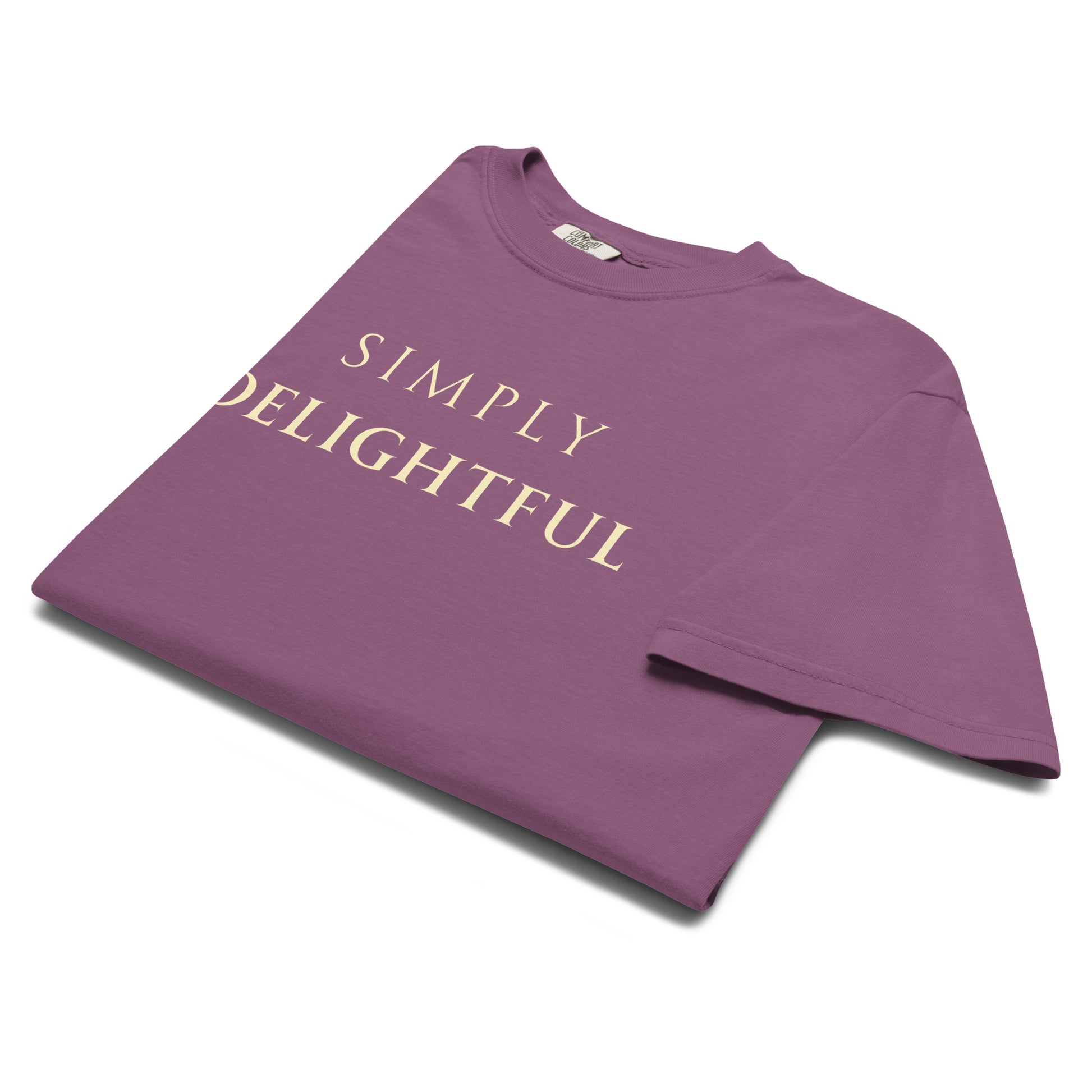 Folded Simply Delightful Comfort Colors graphic T-shirt in Berry showing cream text detail
