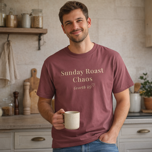 Man wearing burgundy Sunday Roast Chaos Comfort Colors T-shirt in cosy kitchen setting holding a mug
